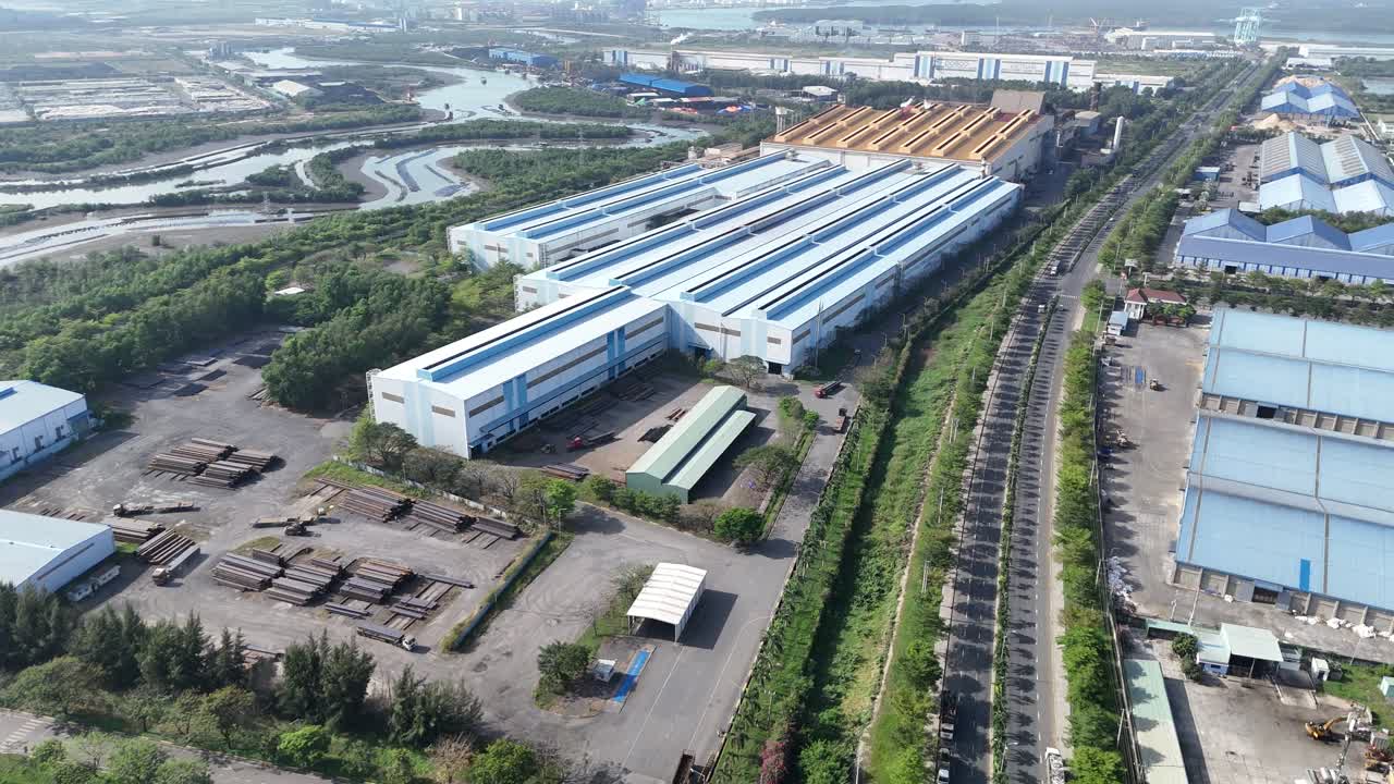 Vista aérea de um parque industrial com galpões de produção e pátio de materiais