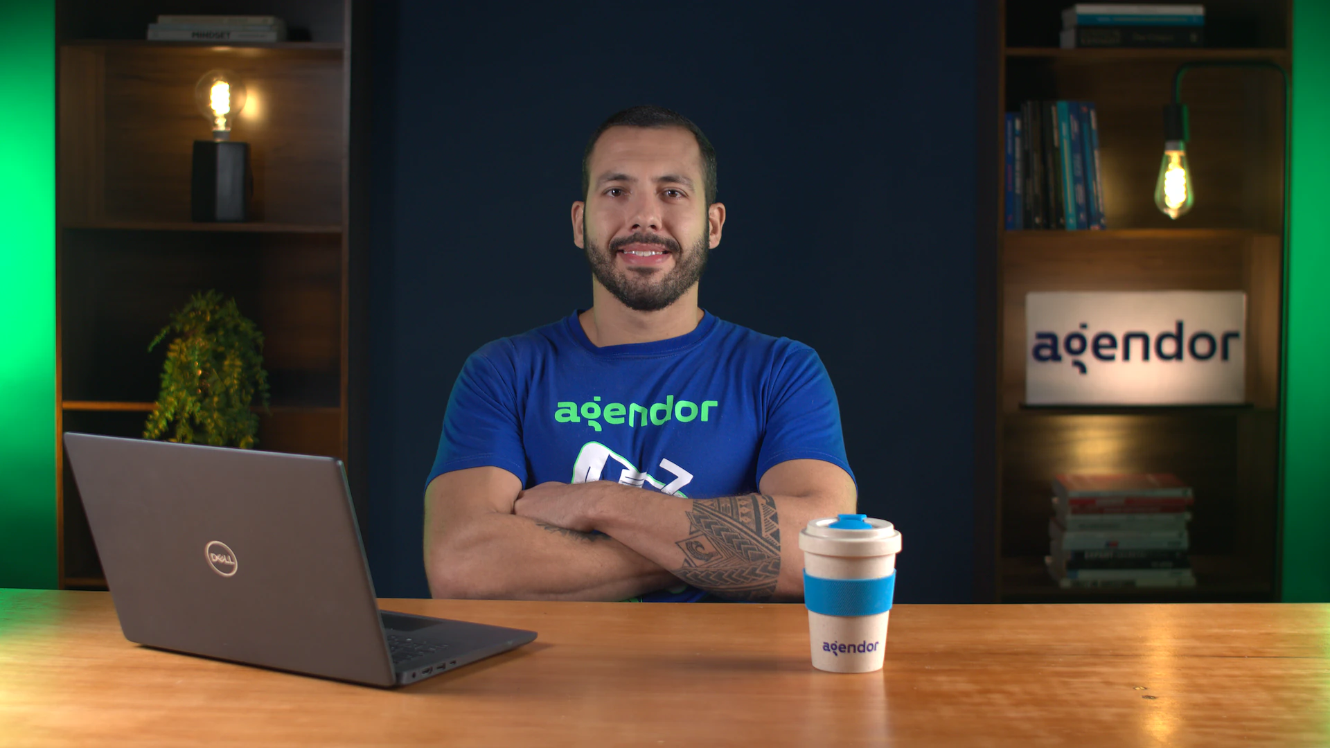 Especialista do Agendor de camiseta da marca em reunião de acompanhamento, com notebook sobre a mesa.